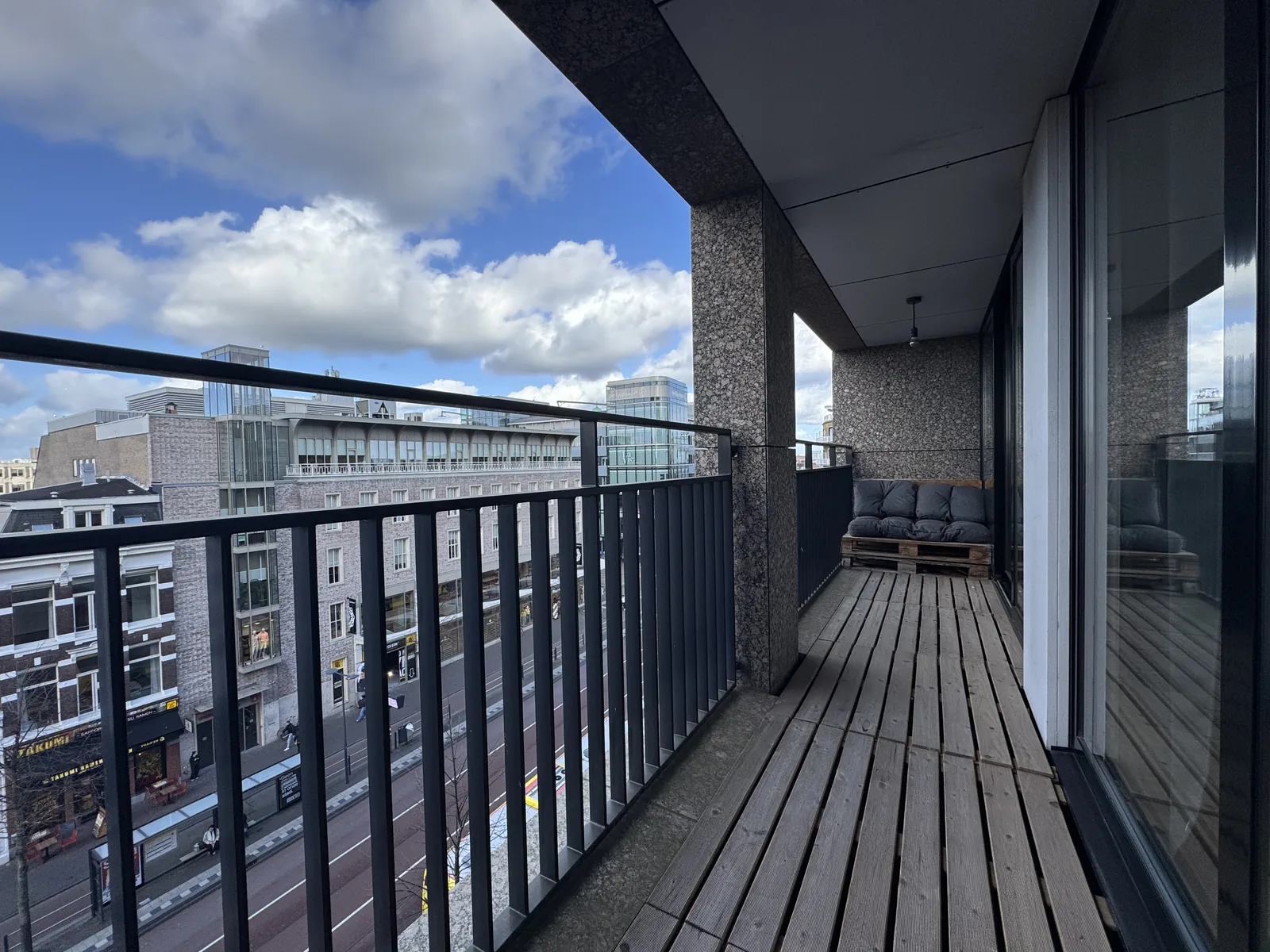 Balcony with pallet lounge furniture overlooking Vredenburg square and Utrecht city centre skyline